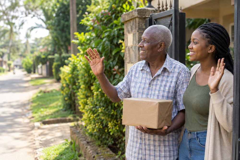 Elderly man and his granddaughter receiving a discreet parcel at the gate